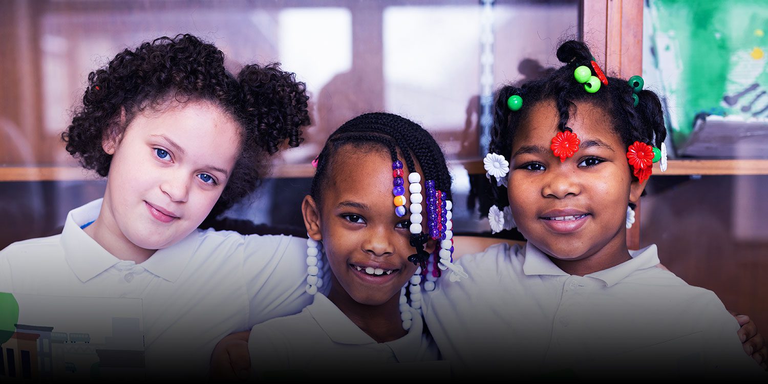 Smiling students standing together in a classroom.